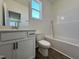 Bright bathroom with a single sink vanity, toilet, and a shower-tub combination at 150 W Saltgrass Ln, Smithfield, NC 27577
