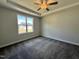 Bright bedroom featuring tray ceilings, a large window, and plush carpet at 160 W Saltgrass Ln, Smithfield, NC 27577