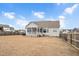 Rear view of house showcasing screened porch and yard at 1704 Little Drake Ave, Willow Springs, NC 27592