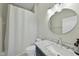 Clean bathroom with marble vanity, round mirror, and updated fixtures at 200 S Dawson St # 406, Raleigh, NC 27601