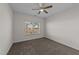 A sunlit bedroom with neutral walls, carpet flooring, and a ceiling fan at 256 Barbour Farm Ln, Four Oaks, NC 27524