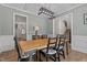 Dining room with a rectangular light wood table and six black chairs with white cushions, and view of staircase at 467 Joseph Alexander Dr, Fuquay Varina, NC 27526