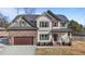 Two-story house with stone and shingle accents, double garage, and landscaping at 467 Joseph Alexander Dr, Fuquay Varina, NC 27526