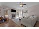 Bright living room featuring a stone fireplace, hardwood floors, ceiling fan and neutral colored furniture at 467 Joseph Alexander Dr, Fuquay Varina, NC 27526