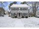 Two-story gray house with white accents, snow-covered lawn, and American flag at 6617 Portsmouth Ln, Raleigh, NC 27615