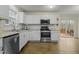 White kitchen with stainless steel appliances and deck access at 6645 Austin Creek Dr, Wake Forest, NC 27587