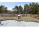 Spacious backyard with a stone-paved patio area, a fire pit, and a wooden fence at 701 Occoneechee Dr, Fuquay Varina, NC 27526