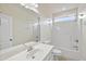 Bright bathroom featuring a large mirror, white vanity, and a shower-tub combination at 701 Occoneechee Dr, Fuquay Varina, NC 27526