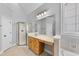 A bright bathroom vanity with a glass shower and decorative window at 701 Occoneechee Dr, Fuquay Varina, NC 27526