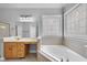 Corner bathtub and a bright vanity with decorative tile detail at 701 Occoneechee Dr, Fuquay Varina, NC 27526