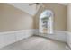 A well-lit bedroom featuring plush carpet, neutral walls and a large arch window at 701 Occoneechee Dr, Fuquay Varina, NC 27526
