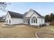 Charming white house with gray roof, blue shutters, and manicured lawn at 701 Occoneechee Dr, Fuquay Varina, NC 27526