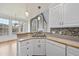 Well-lit kitchen featuring white cabinets, a mosaic backsplash, and stainless steel appliances at 701 Occoneechee Dr, Fuquay Varina, NC 27526