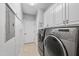 Laundry room with modern appliances and convenient overhead cabinet storage at 701 Occoneechee Dr, Fuquay Varina, NC 27526