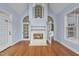 Living room with fireplace and glass doors opening up to a sunroom, hardwood floors at 701 Occoneechee Dr, Fuquay Varina, NC 27526