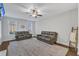 Living room featuring a fireplace, ceiling fan, and comfortable leather sofas at 7949 Parker Mill Trl, Fuquay Varina, NC 27526