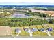 Aerial view displays several homes surrounded by trees and farmland, with a lake in the background at 798 Christian Light Rd, Fuquay Varina, NC 27526
