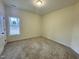 A bright bedroom with a large window, neutral carpet and a closet at 100 Preacher Ln, Angier, NC 27501