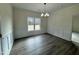 A spacious dining room features elegant wainscoting, modern light fixture and beautiful hardwood floors at 100 Preacher Ln, Angier, NC 27501