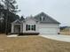 Two-story house with gray and beige siding, two-car garage, and landscaped yard at 100 Preacher Ln, Angier, NC 27501