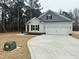 A single-Gathering home featuring a spacious driveway, a two-car garage, and wooded surroundings at 100 Preacher Ln, Angier, NC 27501