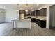 A well-lit kitchen with granite countertops, an island with a sink, and dark wood cabinetry at 100 Preacher Ln, Angier, NC 27501