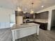 Bright kitchen showcasing a large island, granite countertops, pendant lights, and stainless appliances at 100 Preacher Ln, Angier, NC 27501