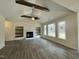 Open-concept living room with a fireplace, wooden beams and shelves, and ample natural light at 100 Preacher Ln, Angier, NC 27501