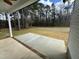 Covered patio with a ceiling fan looks out onto a level backyard with mature trees at 100 Preacher Ln, Angier, NC 27501