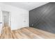 Spacious bedroom with hardwood floors, a geometric accent wall, and a walk-in closet at 1040 Southern High School Rd, Burlington, NC 27215