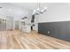 Open-concept living space showcases the kitchen, wood flooring, a modern chandelier, and unique wainscoting at 1040 Southern High School Rd, Burlington, NC 27215