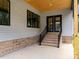 Spacious patio with brick base, wood ceiling, black trimmed windows and door to interior at 1040 Southern High School Rd, Burlington, NC 27215