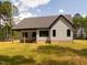Backyard view of this new house featuring a gray exterior, windows and green lawn at 1040 Southern High School Rd, Burlington, NC 27215