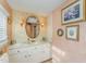 Bathroom with updated vanity, decorative mirror, and floral wallpaper at 110 E Orange St, Hillsborough, NC 27278