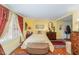Comfortable bedroom with sunny yellow walls and hardwood floors at 110 E Orange St, Hillsborough, NC 27278