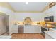 Well-lit kitchen features white cabinets, stainless steel appliances, and tiled floor at 110 E Orange St, Hillsborough, NC 27278