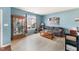 Bright living room with neutral tones, a display case, and large windows overlooking the yard at 112 Smith Rock Dr, Holly Springs, NC 27540