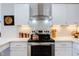 White kitchen cabinets, stainless steel appliances, copper kettle at 1309 Hudson Ave # D11, Durham, NC 27705