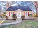 Beige house with red shutters, a white door, and a landscaped yard at 1606 Granville St, Burlington, NC 27215