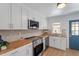 Updated kitchen featuring white cabinets, butcher block countertops, and stainless steel appliances at 1606 James St, Durham, NC 27707