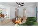 Bright living room with view to a bedroom, featuring a modern ceiling fan, and comfortable green armchairs at 1606 James St, Durham, NC 27707