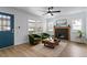 Inviting living room with a fireplace, modern ceiling fan, and views of the landscaped outdoors at 1606 James St, Durham, NC 27707