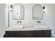 Double vanity bathroom with white subway tile and arched mirrors at 2119 Brewer St, Raleigh, NC 27608