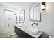 Modern bathroom with double sinks, walk-in shower, and arched mirrors at 2119 Brewer St, Raleigh, NC 27608