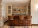 A home bar featuring a wood counter, stone backsplash, glass shelves, and seating for three at 32602 Archdale, Chapel Hill, NC 27517