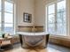 Luxurious bathroom features a freestanding soaking tub and large windows with scenic views at 32602 Archdale, Chapel Hill, NC 27517