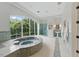 Bright bathroom featuring a soaking tub with pebble surround, large windows and a glass shower enclosure at 32602 Archdale, Chapel Hill, NC 27517