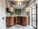 Luxurious bathroom with marble walls and floors, featuring a large mirror, custom wood vanity, and access to a balcony at 32602 Archdale, Chapel Hill, NC 27517