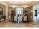 Formal dining room featuring elegant chandeliers, decorative columns, and classic wallpaper at 32602 Archdale, Chapel Hill, NC 27517