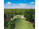 Picturesque aerial view of a golf course featuring mature trees, water features and sand traps under a blue sky at 32602 Archdale, Chapel Hill, NC 27517